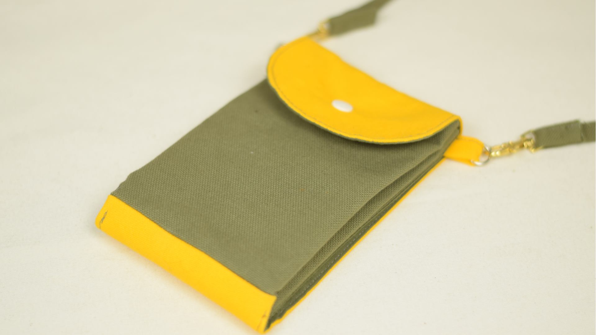 une pochette en tissu vert et jaune avec plusieurs poches et un bouton-pression