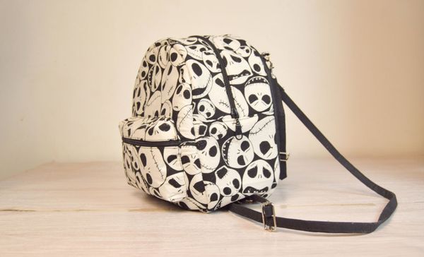 un mini sac à dos en tissu noir et blanc, avec une poche extérieure