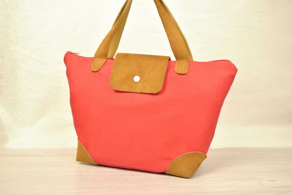 petit sac cabas en tissu rouge, inspiré par le sac Longchamp pliage, avec une anse et des renforcements en cuir