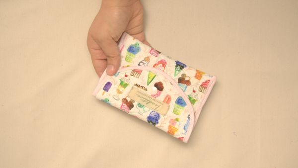 Un joli porte-cartes porte-monnaie en tissu avec un bouton-pression et du biais