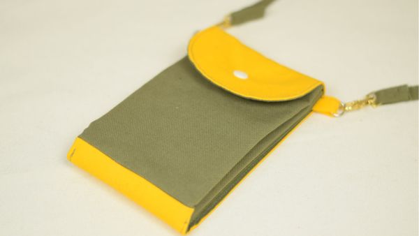 une pochette en tissu vert et jaune avec plusieurs poches et un bouton-pression